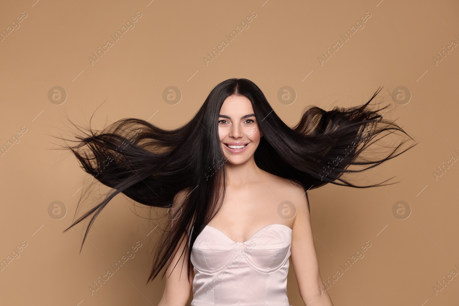 Photo of Portrait of beautiful young woman with healthy strong hair on beige background