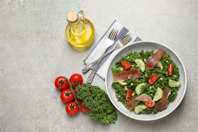 Photo of Delicious kale salad on light grey table, flat lay