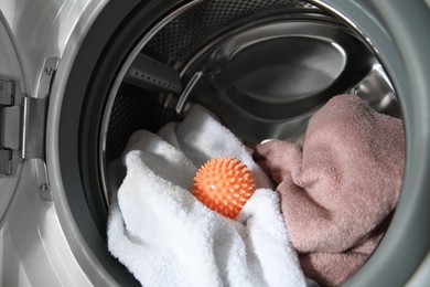 Dryer ball and towels in washing machine, closeup