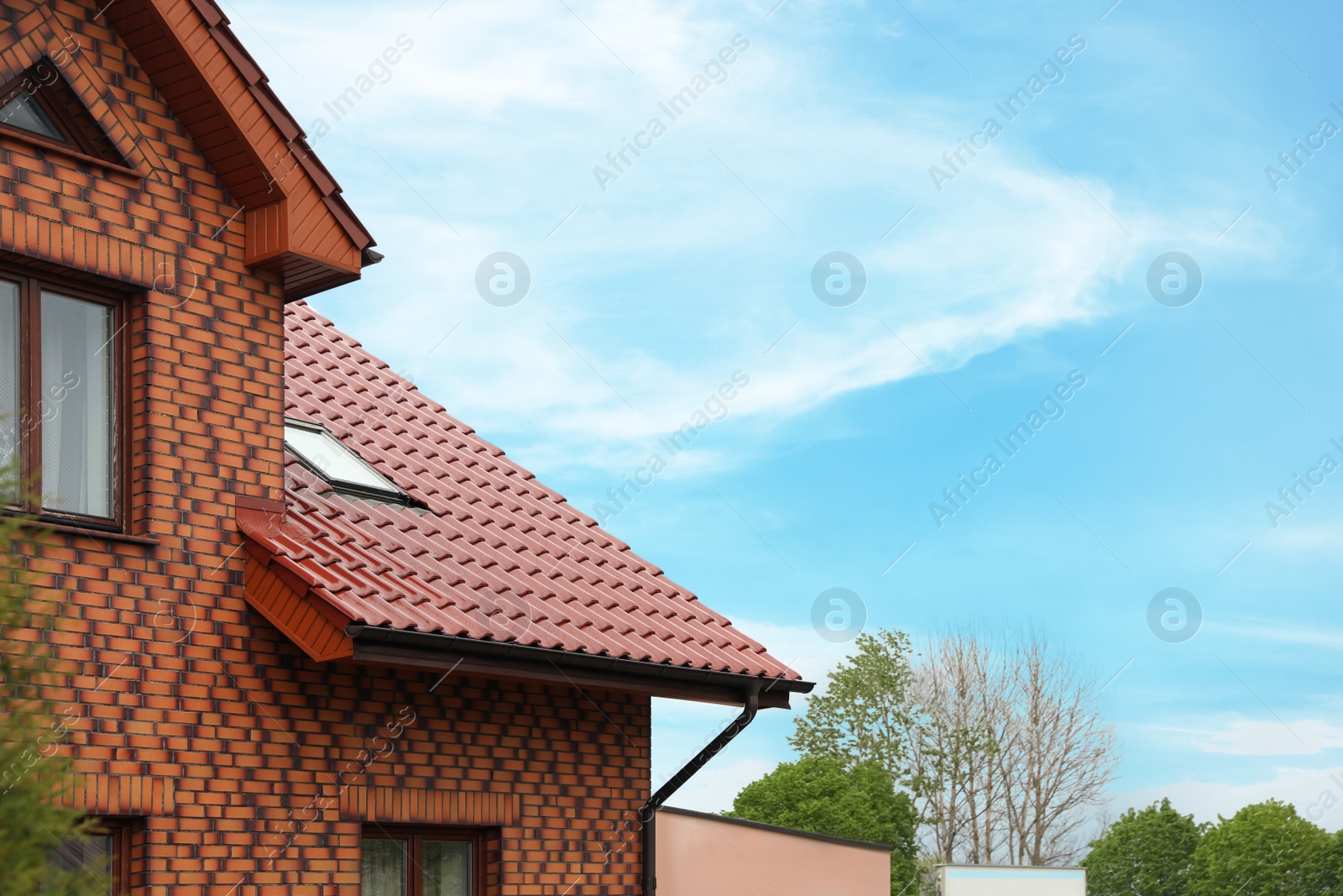 Photo of Beautiful house with red roof against blue sky