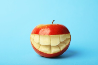 Funny smiling apple on color background