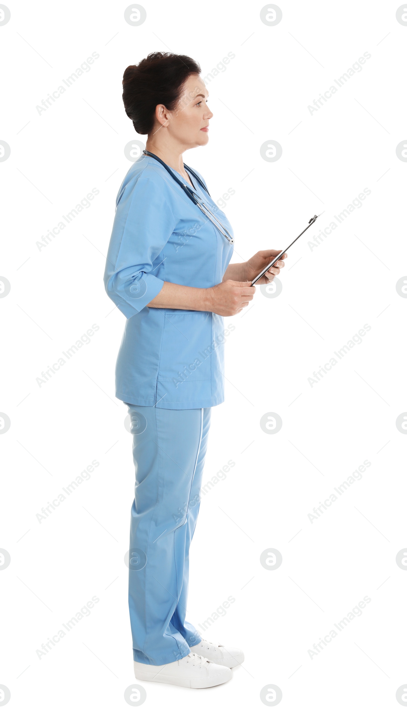 Photo of Full length portrait of female doctor in scrubs with clipboard isolated on white. Medical staff