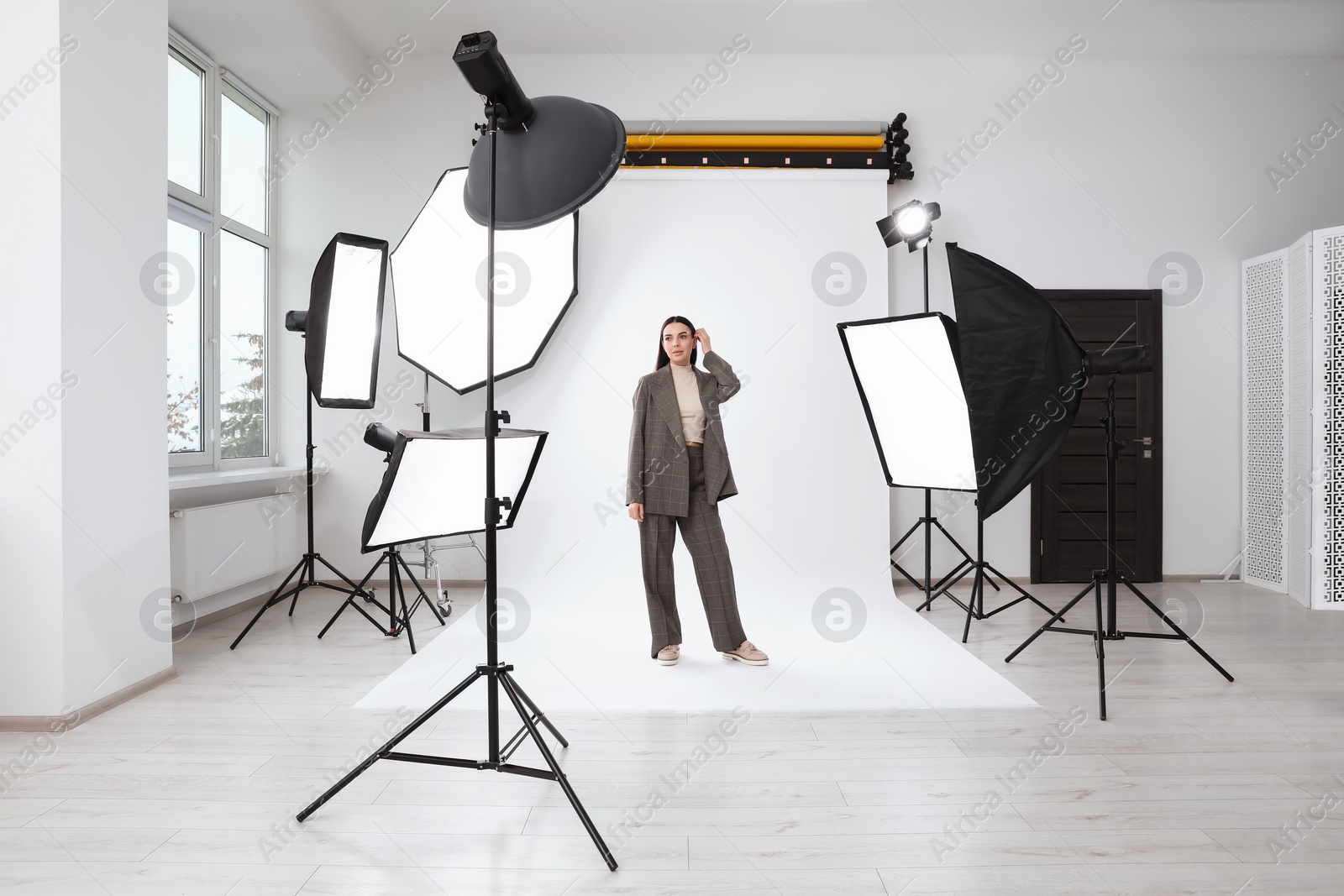 Photo of Beautiful young model posing in modern studio. Professional photo session