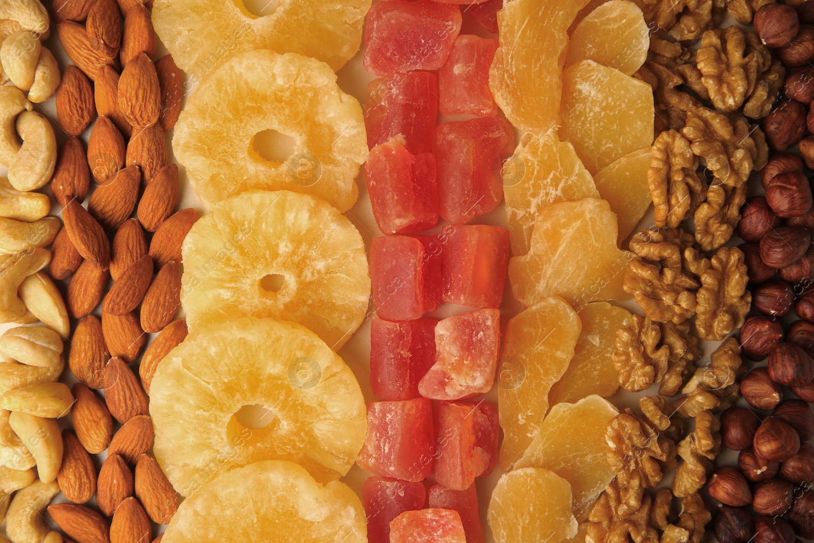 Photo of Different tasty nuts and dried fruits as background, top view