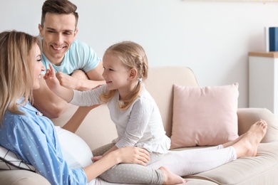 Young pregnant woman with her family at home