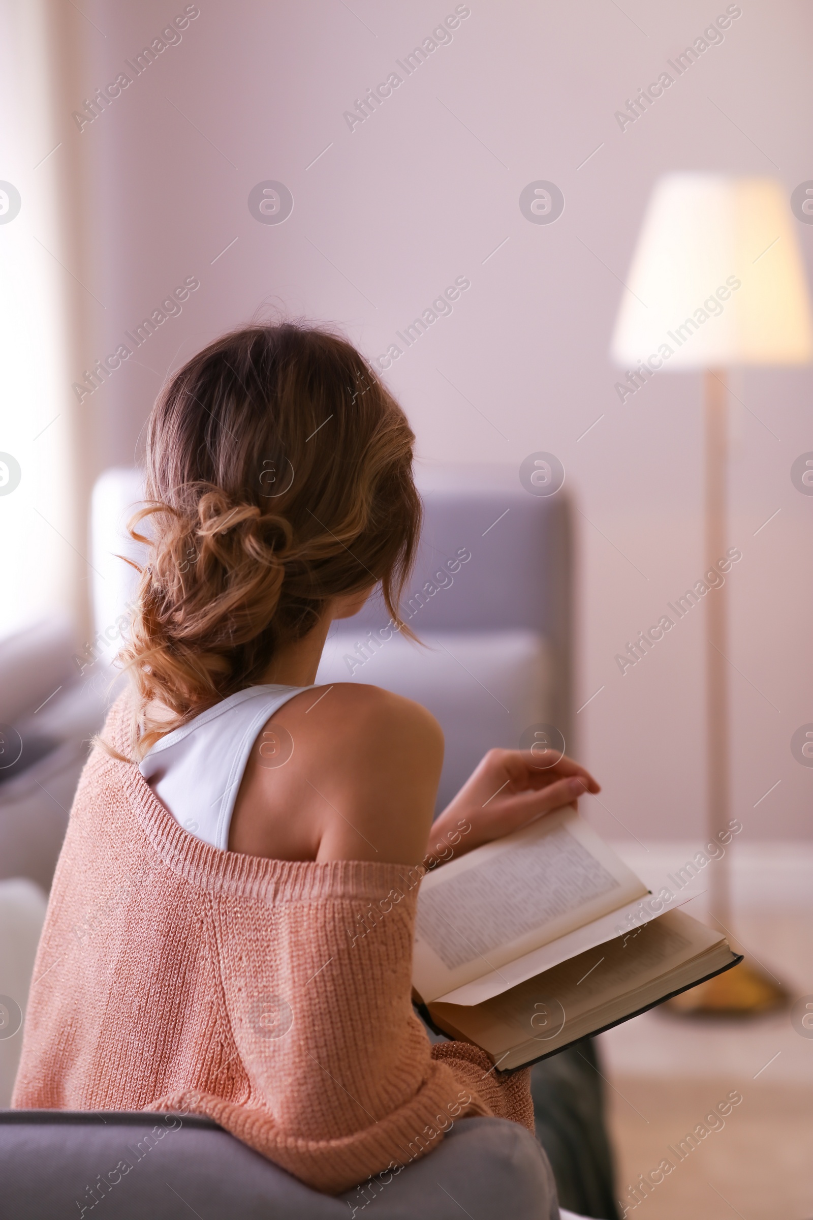 Photo of Beautiful young woman with book relaxing at home. Cozy atmosphere