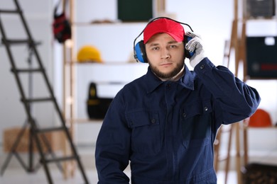 Worker wearing safety headphones indoors. Hearing protection device