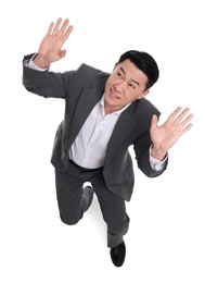 Scared businessman in suit posing on white background, above view