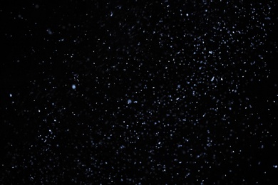 Photo of Snow flakes falling on black background. Winter weather