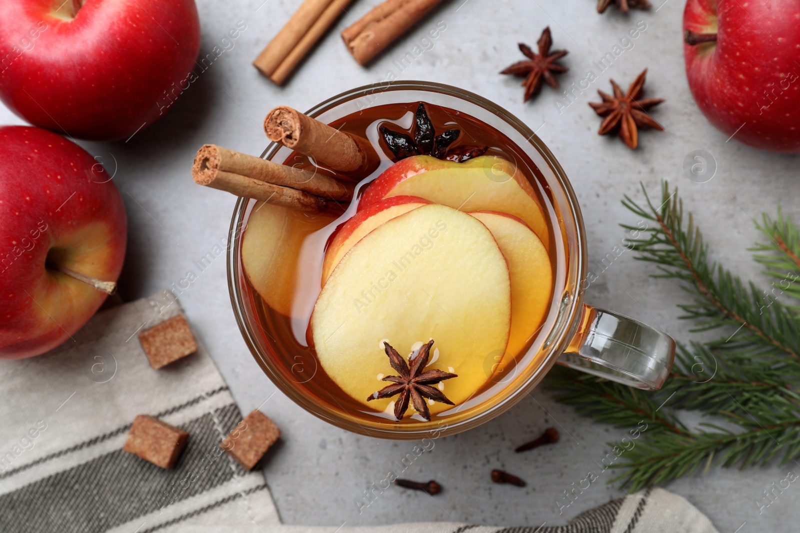 Photo of Aromatic hot mulled cider on grey table, flat lay