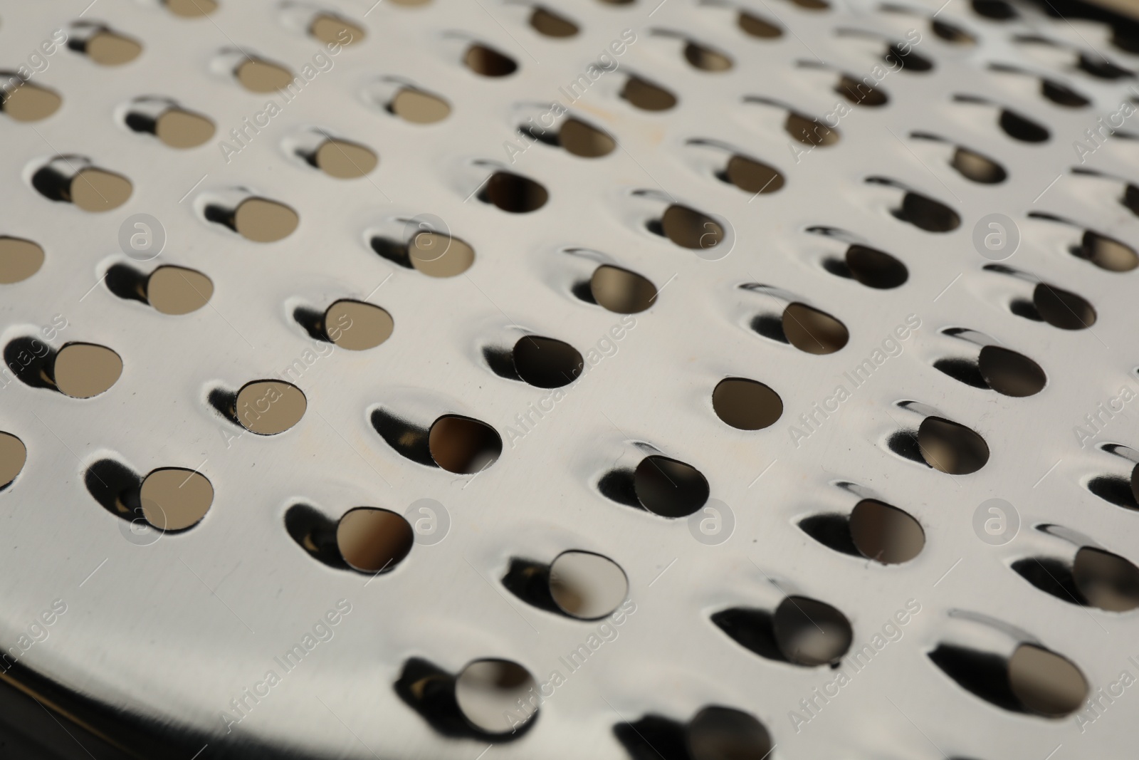 Photo of Modern metal grater as background, closeup view