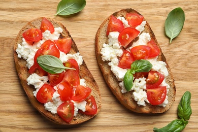 Photo of Flat lay composition with tasty bruschettas on wooden table