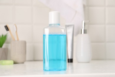 Bottle of mouthwash on white table in bathroom