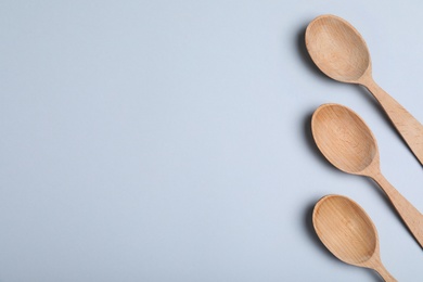 New wooden spoons on white background, top view