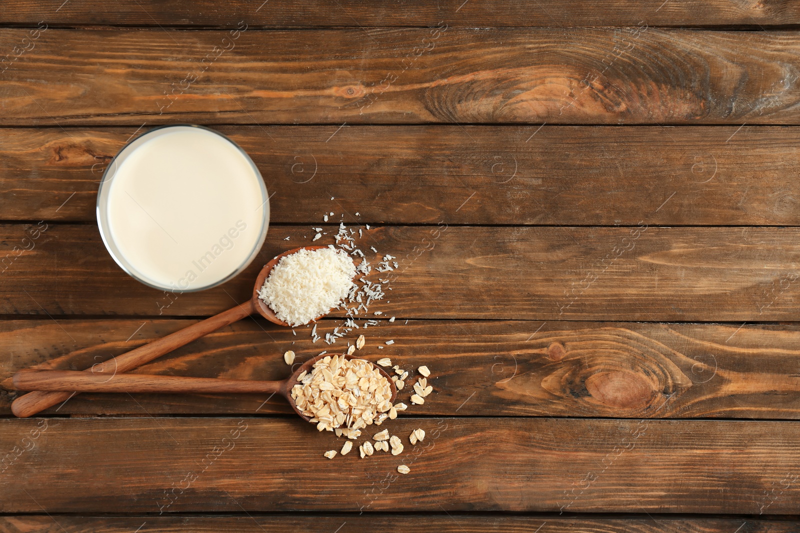 Photo of Glass with coconut and oat milk on wooden background