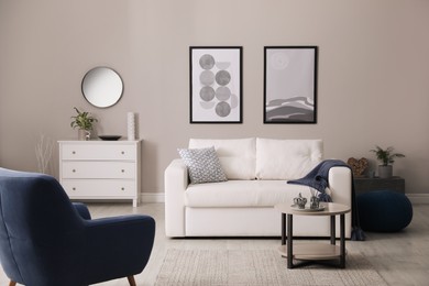 Stylish living room interior with white sofa, armchair and small coffee table