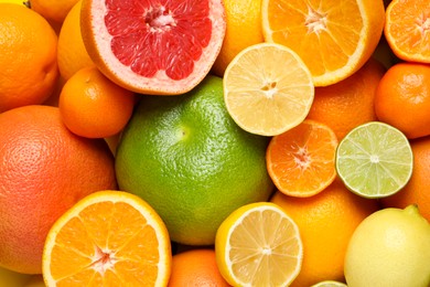 Photo of Different ripe citrus fruits as background, top view