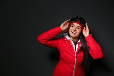 Woman wearing stylish winter sport clothes on black background