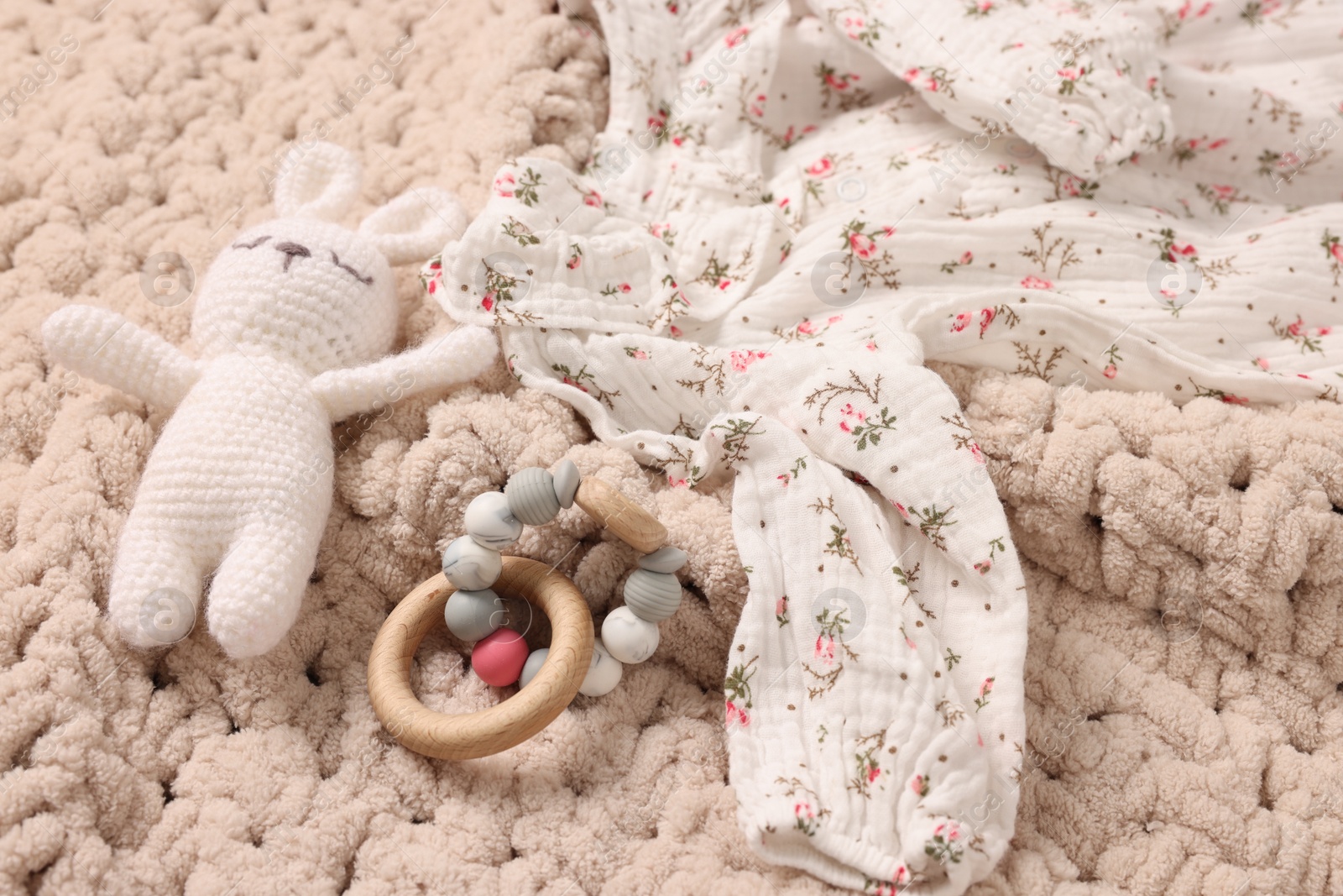 Photo of Baby accessories. Toys and cloth on knitted fabric