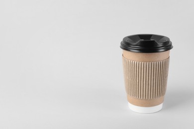 Photo of Paper cup with plastic lid on light background, space for text. Coffee to go