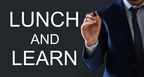 Image of Lunch and Learn concept. Businessman with pen on dark background