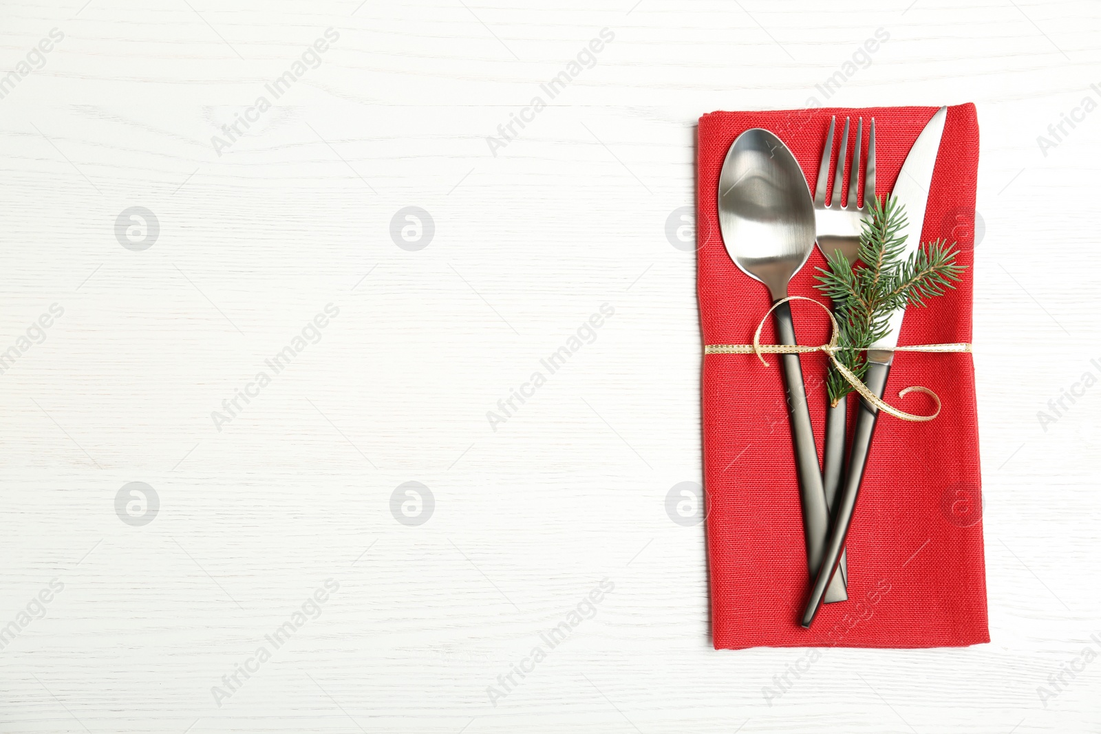 Photo of Cutlery and napkin on wooden background, top view. Table setting