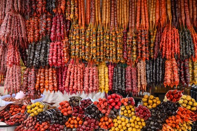 Photo of Bunches of different delicious churchkhelas at market