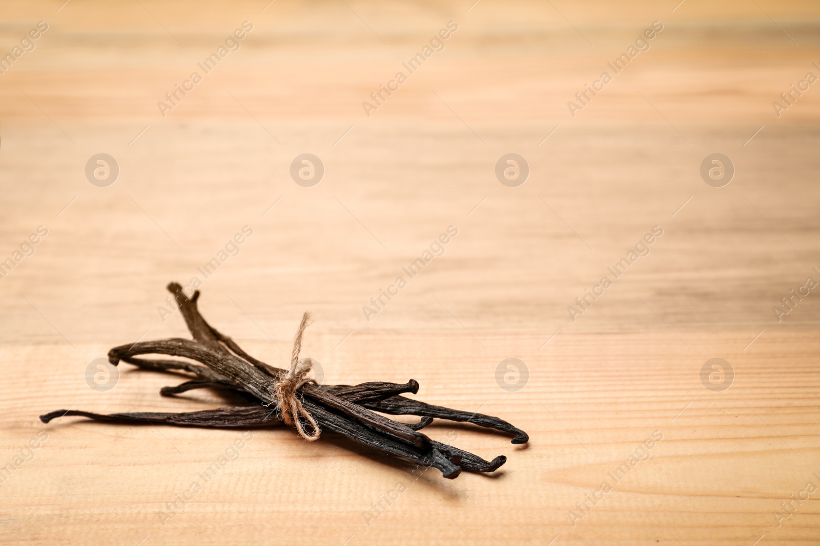 Photo of Aromatic vanilla sticks on wooden background