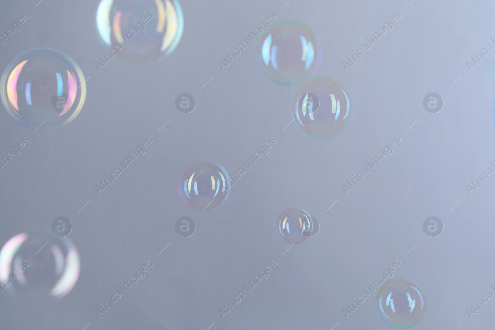 Photo of Beautiful transparent soap bubbles on gray background