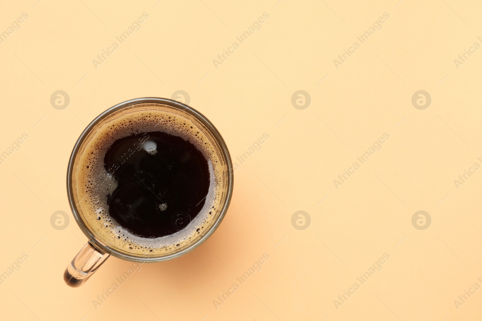 Photo of Fresh coffee in cup on beige background, top view. Space for text