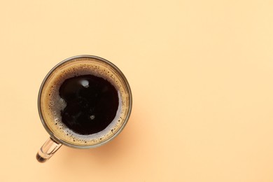Photo of Fresh coffee in cup on beige background, top view. Space for text