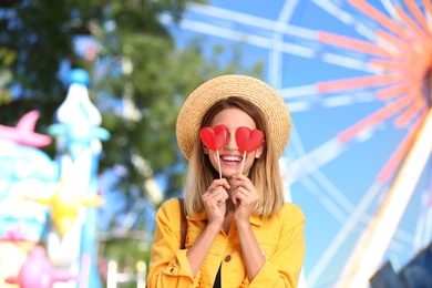 Beautiful woman with candies having fun at amusement park