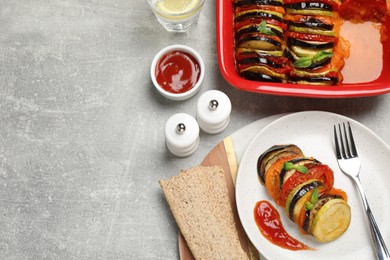 Photo of Delicious ratatouille with basil served on grey table, flat lay. Space for text