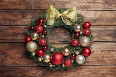 Beautiful Christmas wreath with festive decor on wooden background