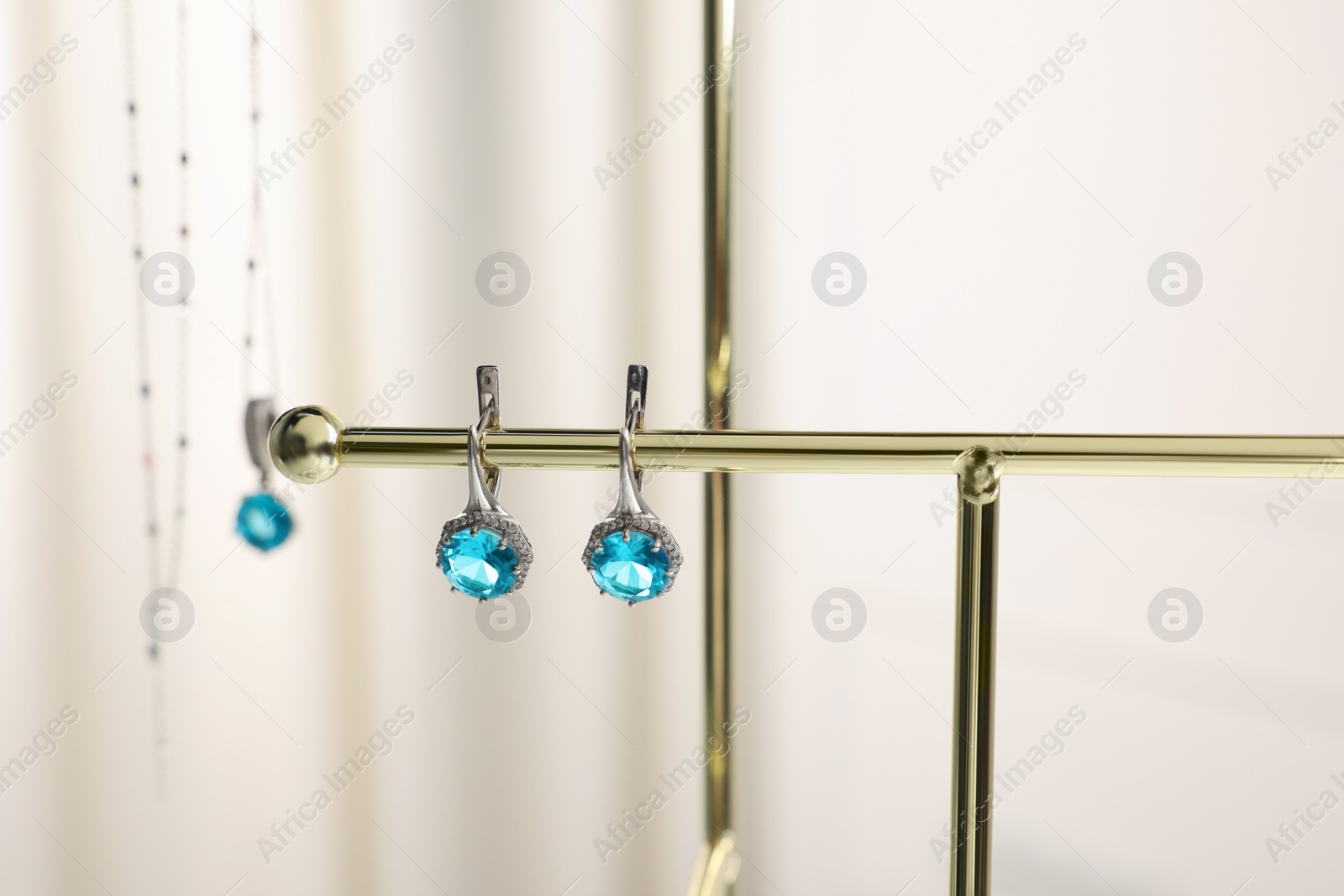 Photo of Beautiful jewelry with light blue gemstones on stand, closeup