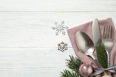 Photo of Cutlery set and festive decor on white wooden table, flat lay with space for text. Christmas celebration