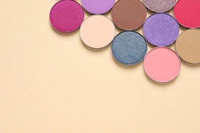 Different beautiful eye shadows on beige background, flat lay. Space for text