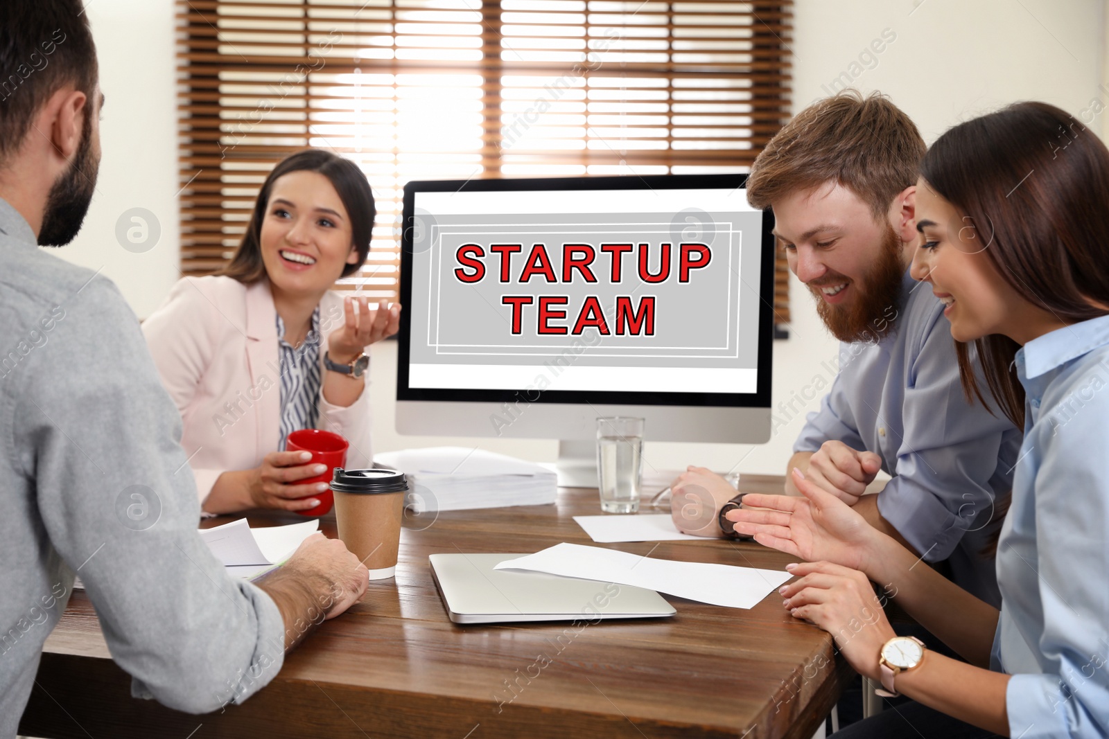 Image of Group of colleagues at table in office. Startup team