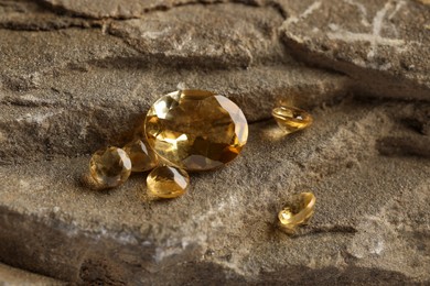 Photo of Beautiful yellow gemstones for jewelry on stone surface, closeup