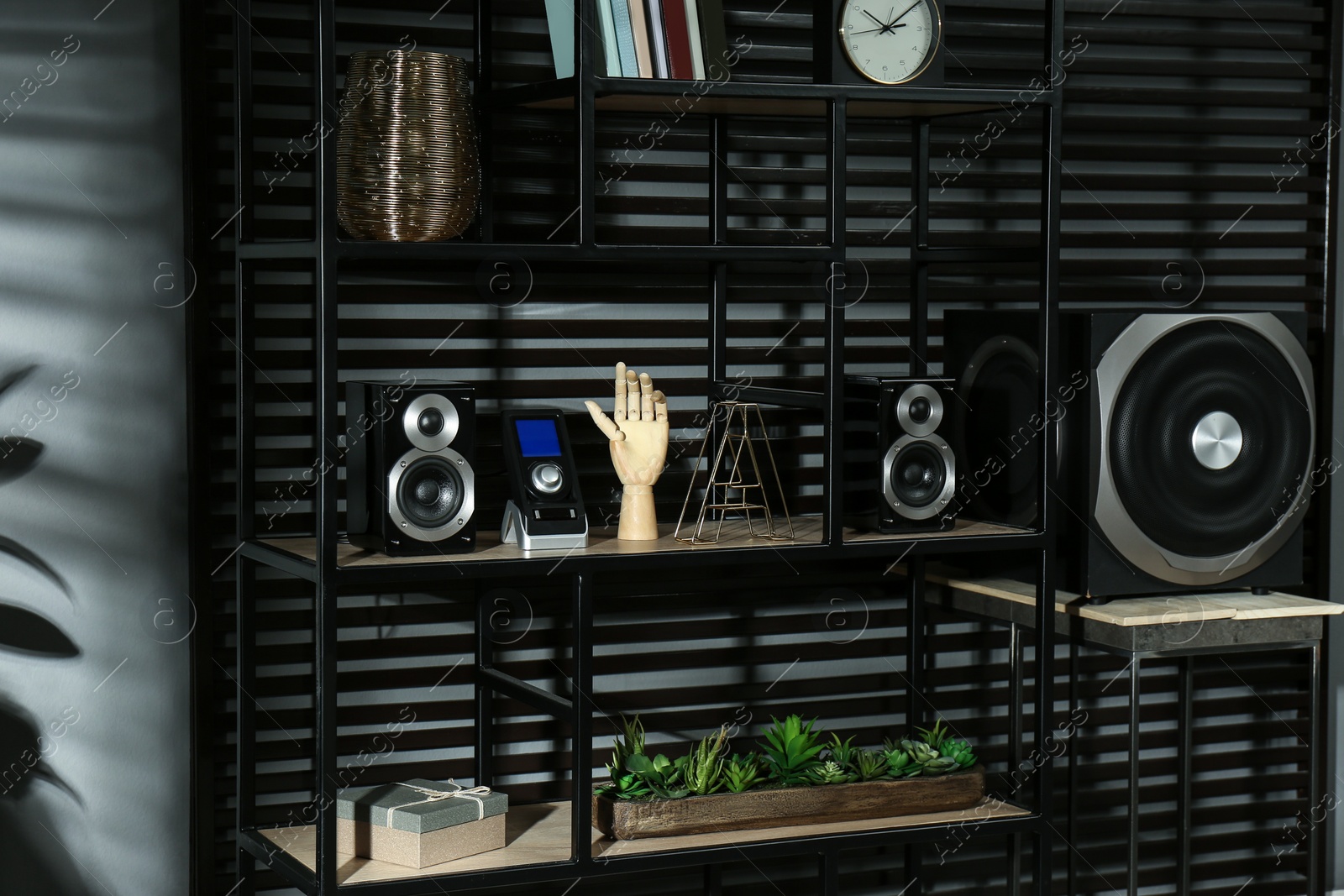 Photo of Modern powerful audio speaker system on shelving indoors