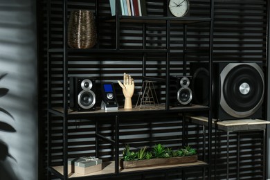 Photo of Modern powerful audio speaker system on shelving indoors