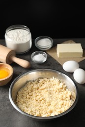 Photo of Making shortcrust pastry. Different ingredients for dough and rolling pin on grey table