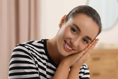 Photo of Portrait of beautiful young woman indoors. Attractive lady smiling and looking into camera