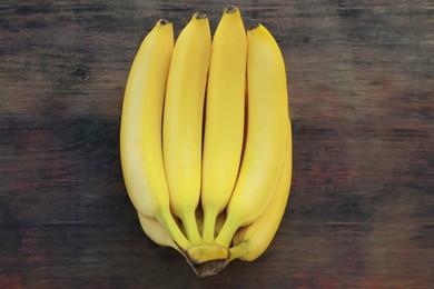 Bunch of ripe yellow bananas on wooden table, top view