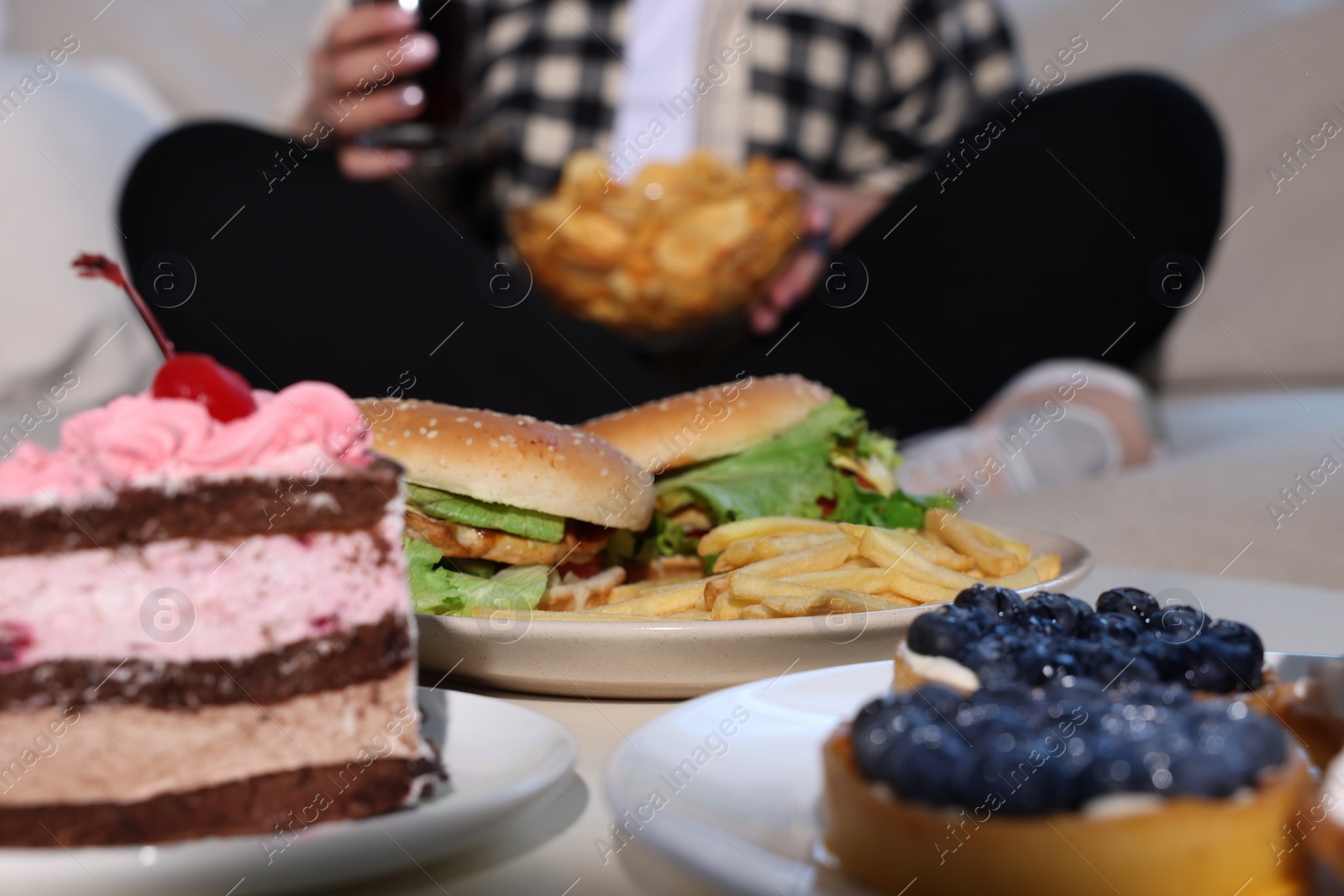 Photo of Overweight woman with chips, focus on unhealthy food