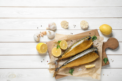 Flat lay composition with tasty smoked fish on white wooden table