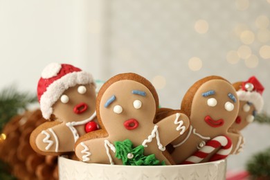 Photo of Delicious homemade Christmas cookies in bowl against blurred festive lights, closeup