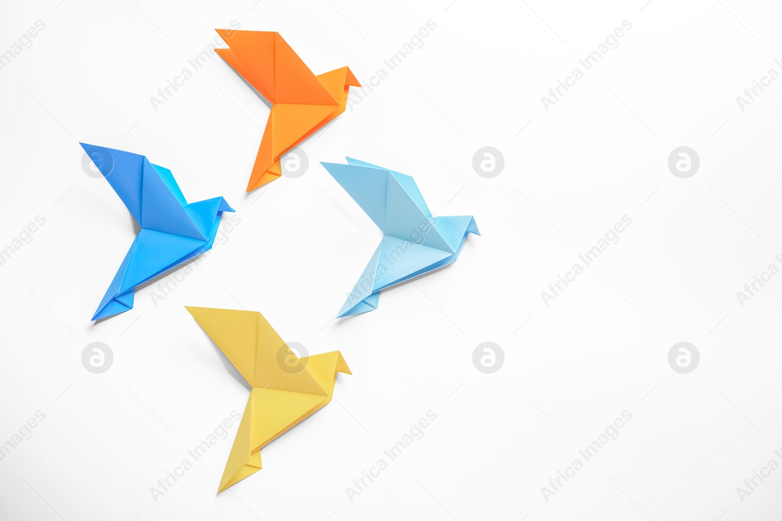 Photo of Beautiful colorful origami birds on white background, flat lay. Space for text