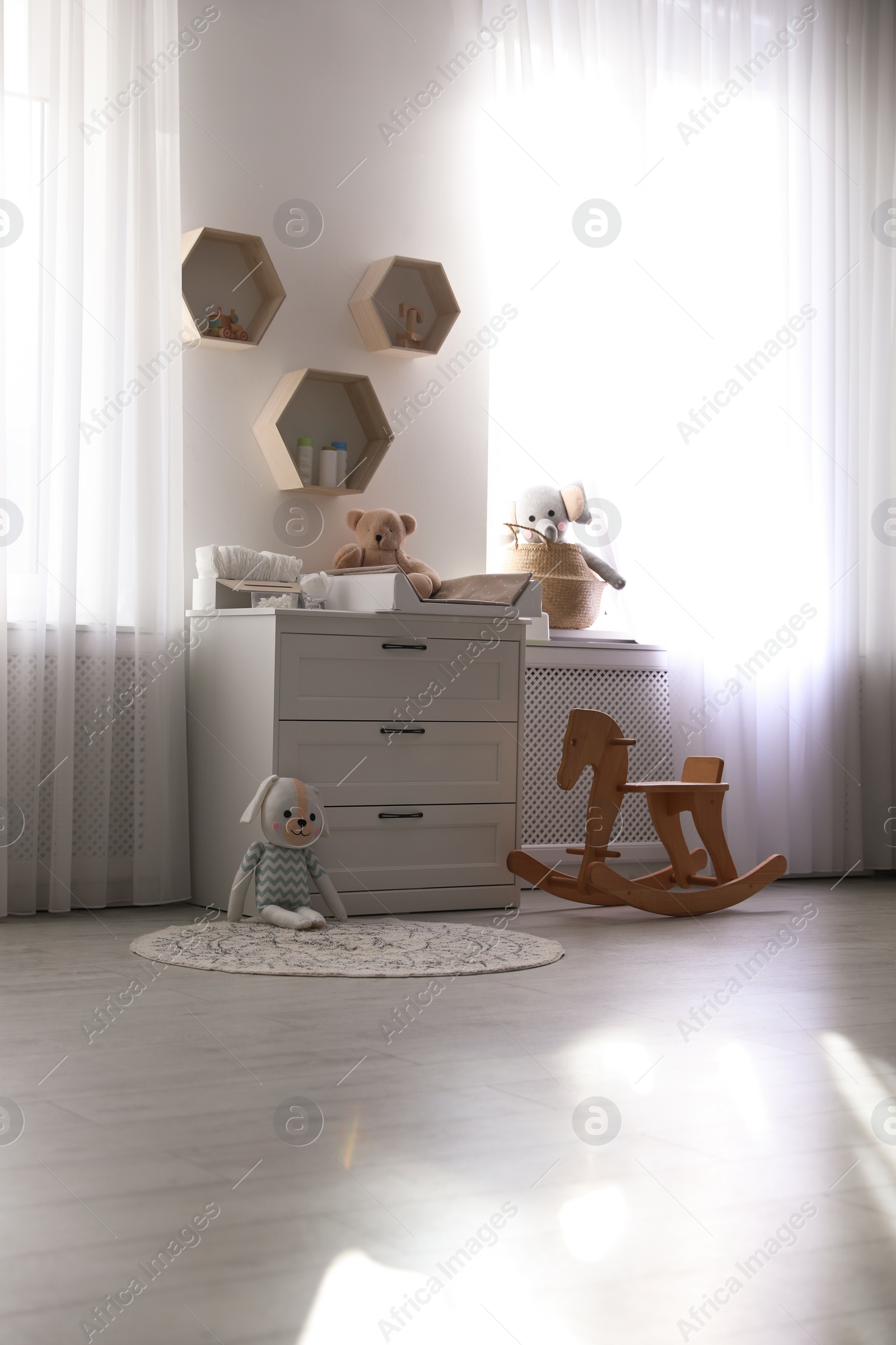 Photo of Beautiful baby room interior with toys and modern changing table