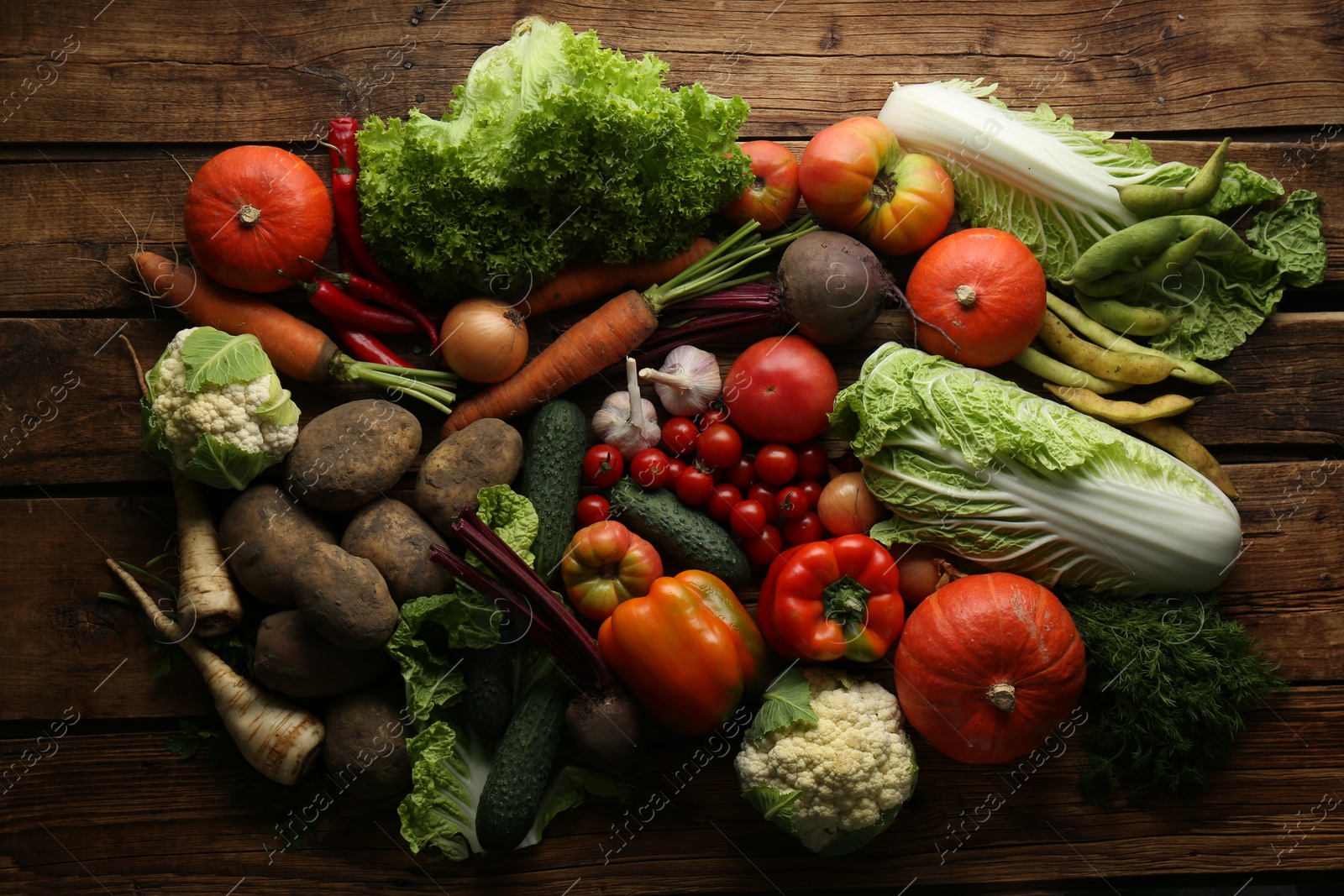 Photo of Different fresh ripe vegetables on wooden table, flat lay. Farmer produce